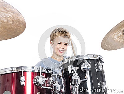 young caucasian boy plays drums in studio against white background Stock Photo