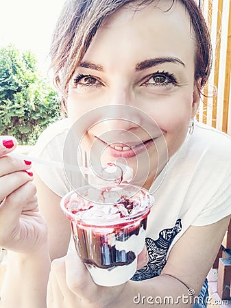 Young caucasian brunette eating creamy ice cream with strawberry Stock Photo