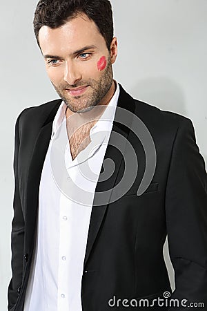 Young caucasian businessman with lipstick kiss mark Stock Photo