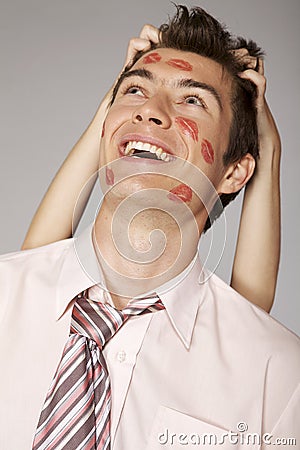 Young caucasian businessman with lipstick kiss mark on his cheek Stock Photo