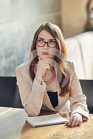 Young caucasian businesswoman with notebook. Woman in glasses in a cafe Stock Photo