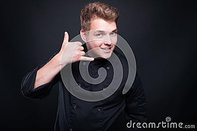 Young caucasian chef making call me gesture Stock Photo