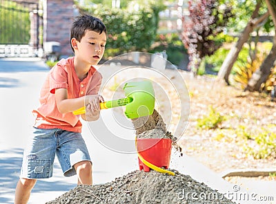 Young Caucasian Chinese Boy Playing with Shovel and Bucket Stock Photo