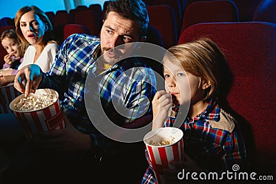 Young caucasian family watching a film at a movie theater Stock Photo