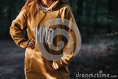 Young, Caucasian female wearing a yellow hoodie in a forest in Poland. Editorial Stock Photo
