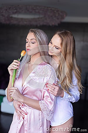 Young lesbian couple smelling tulip indoor Stock Photo