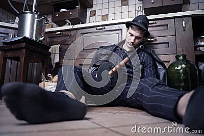 Young caucasian man with gun dead from bootleggers war during alcolol prohibition in USA in 1920-1930s. Concept scene, striped sui Stock Photo