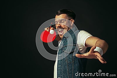 Young caucasian man playing tennis isolated on black studio background in retro style, action and motion concept Stock Photo