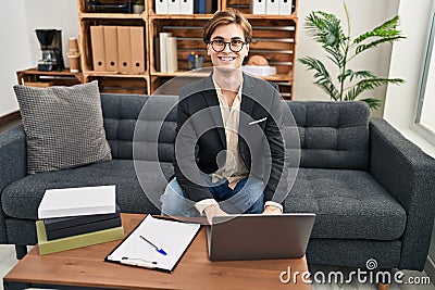 Young caucasian man psychologist using laptop at psychology clinic Stock Photo