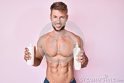 Young caucasian man shirtless holding cream lotion smiling with a happy and cool smile on face Stock Photo