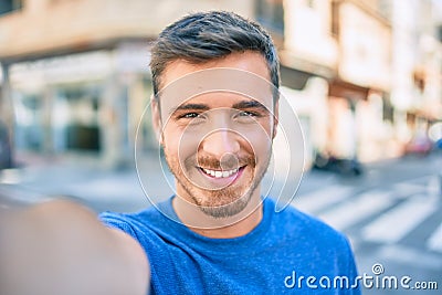 Young caucasian man smiling happy making selfie by the camera at the city Stock Photo