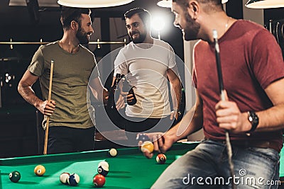 young caucasian men drinking beer beside billiard table Stock Photo