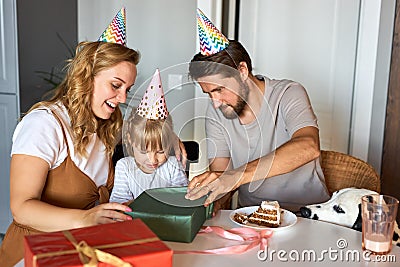 Young caucasian mother and father love their daughter, congratulate Stock Photo