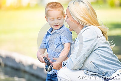 Young Caucasian Mother and Son Having Fun Fishing At The Lake Stock Photo