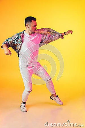 Young caucasian musician, dancer, party host, DJ on gradient background in neon light Stock Photo