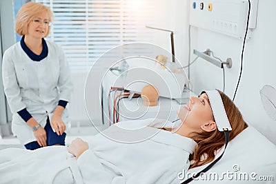Young caucasian sick woman in hospital and her sympathetic nurse Stock Photo