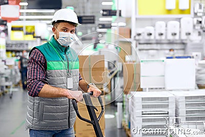 Warehouse worker with hand pallet truck with package shipment sending to customers Stock Photo