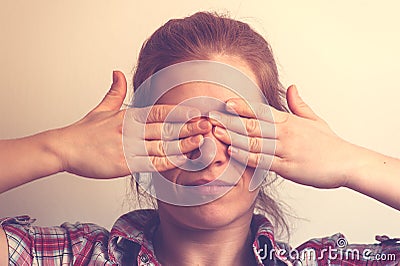 Young Caucasian woman covering her eyes with hands Stock Photo