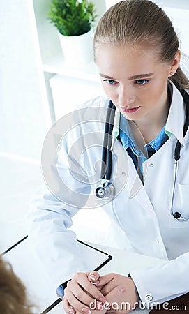 Young Caucasian woman doctor holding female patient`s hand for encouragement and empathy. Partnership trust and medical Stock Photo