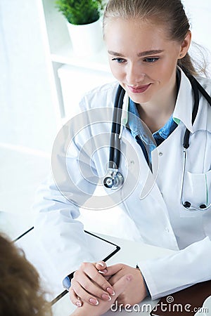 Young Caucasian woman doctor holding female patient`s hand for encouragement and empathy. Partnership trust and medical Stock Photo