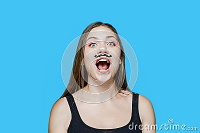 Young caucasian woman with drawn moustache on her face screams, opening the mouth Stock Photo