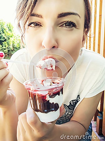 Young caucasian woman eating creamy ice cream with strawberry to Stock Photo