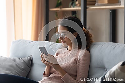 Caucasian woman in glasses using cellphone at home Stock Photo