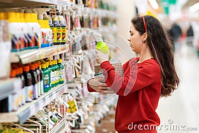 A young Caucasian woman holds pots for seedlings, flower seeds and fertilizer for plants. Close up. Concept of gardening and Stock Photo