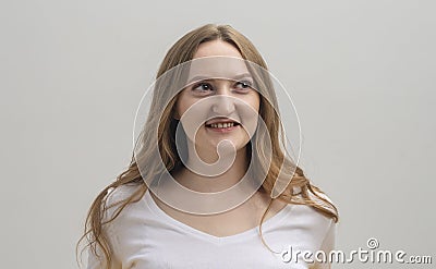 Young caucasian woman interested in coversation and looking aside over grey background Stock Photo