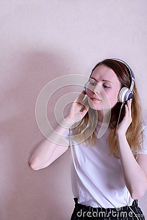 Young caucasian woman is listening to music in headphones Stock Photo