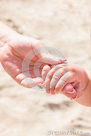 Young Caucasian Woman Mother Holds Hand of Little Baby Toddler. Bright Sunny Summer Day. Beach Sand Seashore. Family Vacation Stock Photo