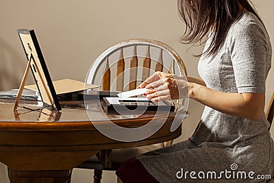 A young caucasian woman is placing a printed photograph into a picture frame with kickstand. Stock Photo
