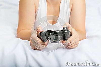 Young caucasian woman playing video game console on the bed Stock Photo