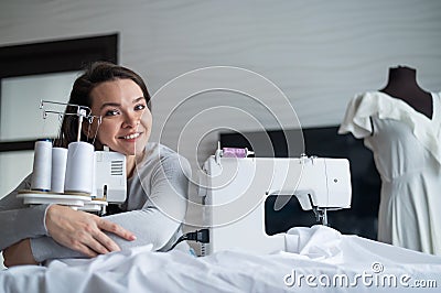 Young caucasian woman sews at home Stock Photo