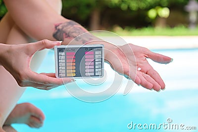 Unrecognizable woman show ph and cl kit and a pill to test the water quality. Stock Photo