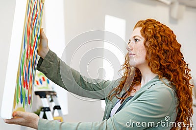 Young caucasian woman standing in art gallery front of paintings Stock Photo