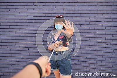 Young caucasian woman wearing face mask and keeping a meter of distance with other person Stock Photo