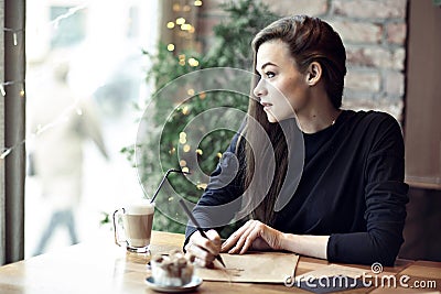 Young caucasian woman working, writing in a restaurant. Business concept. Stationary layouts Stock Photo