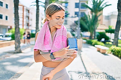 Young cauciasian fitness woman wearing sport clothes training outdoors wearing arm band with smartphone Stock Photo
