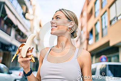 Young cauciasian fitness woman wearing sport clothes training outdoors eating healthy banana for strength and energy Stock Photo