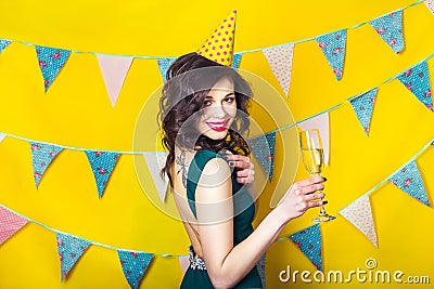 Young celebrating woman green dress, holding a glass of champagne. Stock Photo