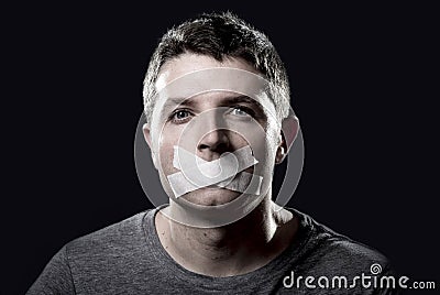 Young censored man mouth sealed on tape to prevent free speaking Stock Photo