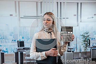 Young charming caucasian woman in suit hold calculator in business cetner Stock Photo