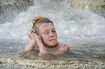 Young charming girl bathes in the healing thermal mineral springs in the resort of Saturnia Italy Stock Photo