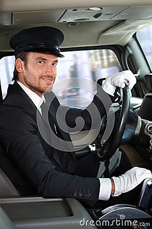 Young chauffeur in limousine smiling Stock Photo