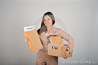 Young cheerful businesswoman with resignation letter celebrating after quitting her job Stock Photo