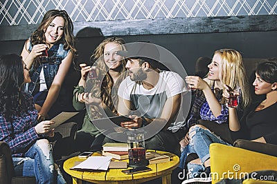 Young cheerful company of friends with mobile, tablet and tea co Stock Photo