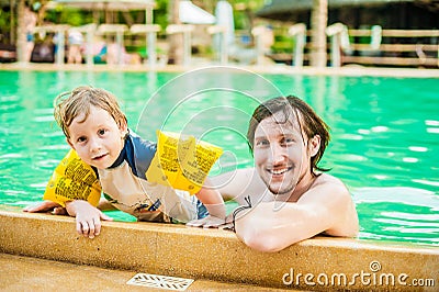 Young cheerful father and son in a swimming pool Stock Photo