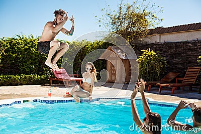 Young cheerful friends smiling, laughing, relaxing, swimming in pool. Stock Photo