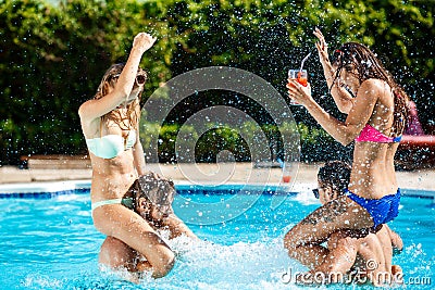 Young cheerful friends smiling, laughing, relaxing, swimming in pool. Stock Photo